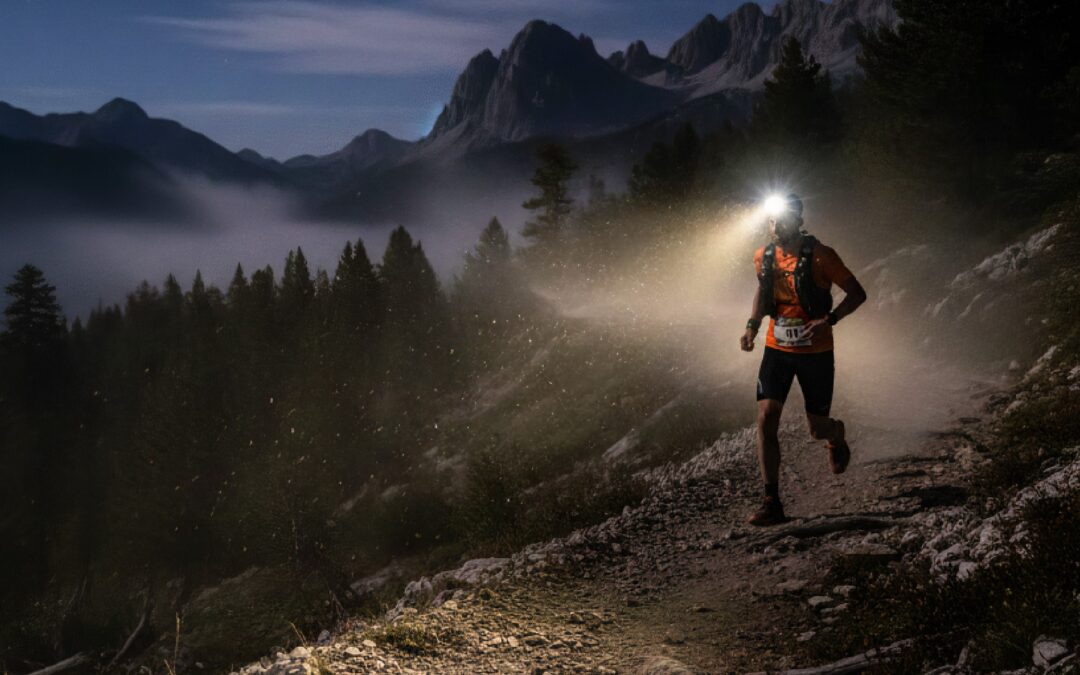 traileur de nuit sur sentier avec lampe frontrale trail